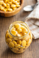 Lupini beans in brine. Pickled lupin in jar on kitchen table.
