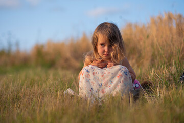 Portrait of attractive lovely baby girl on the summer field