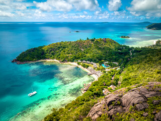 Fototapeta na wymiar Praslin Seychelles tropical island with withe beaches and palm trees. Aerial view of tropical paradise bay with granite stones and turquoise crystal clear waters of Indian Ocean