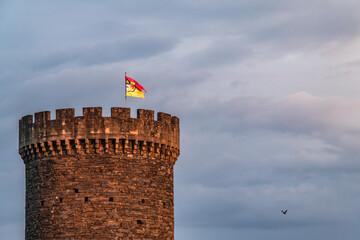 Allassac (Corrèze, France) - Tour César au coucher du soleil avec le drapeau portant blason de la ville - 625309676