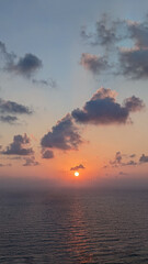 Sunrise over sea, view from beach to open sea and horizon, new day dawning.
