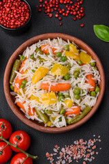 Delicious fresh white boiled rice with vegetables carrots, peppers and asparagus beans on a ceramic plate