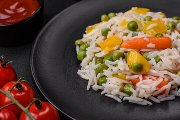 Delicious fresh white boiled rice with vegetables carrots, peppers and asparagus beans on a ceramic plate
