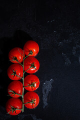 fresh tomatoes on black background with water drops