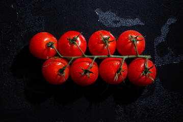 fresh tomatoes on black background with water drops