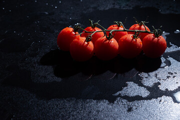 fresh tomatoes on black background with water drops