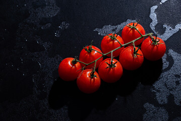 fresh tomatoes on black background with water drops