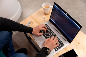 A programmer coding at lap top at coworking space