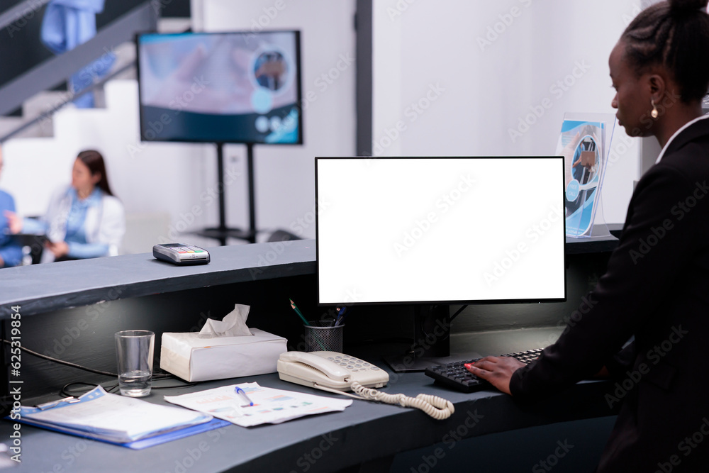 Poster african american receptionist using white isolated screen on computer while working at hospital regi