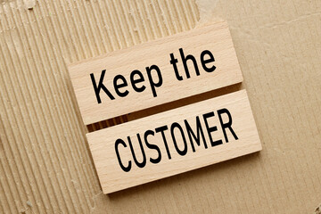 black text on wooden blocks Keep the Customer.