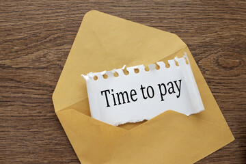 Time To Pay beautiful craft envelope on the desktop. text on torn paper