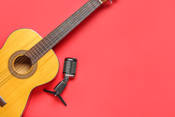 Acoustic guitar and microphone on color background