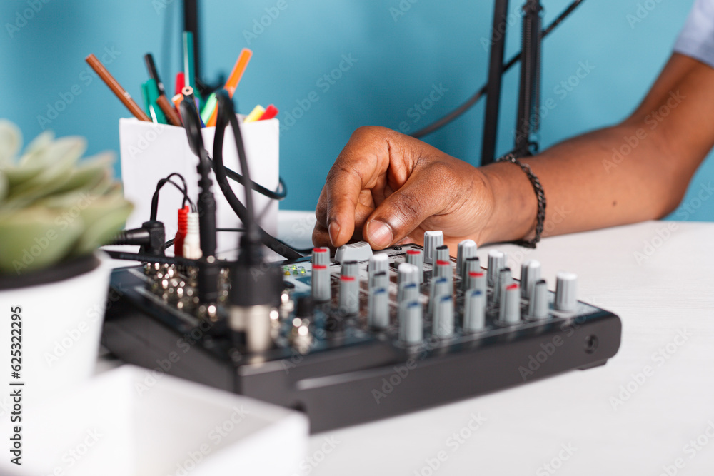 Poster man hand turning knob on sound controller equipment in studio close up. african american blogger usi