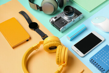 Composition with different gadgets and stationery on color background