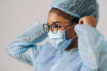 Portrait of young female african american doctor or nurse woman on medical protective wear with mask