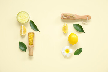 Bowl of lemon body scrub with massage brush and sea salt on pale yellow background