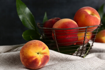 Basket with sweet peaches on dark background