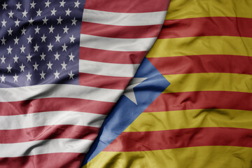big waving colorful flag of united states of america and national flag of catalonia .