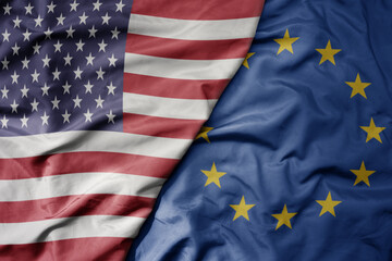 big waving colorful flag of united states of america and national flag of european union.