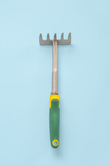 Gardening rake on blue background