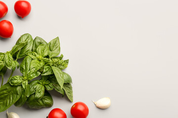 Fresh basil and cherry tomatoes on grey background