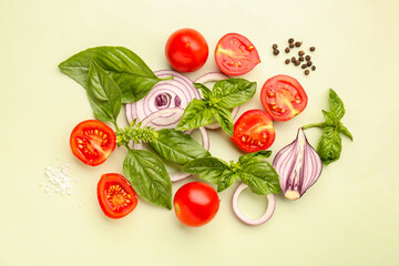 Fresh basil, cherry tomatoes and red onion on green background