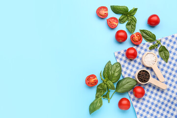 Fresh basil, cherry tomatoes and peppercorn on blue background
