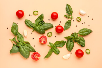 Fresh basil, cherry tomatoes and peppercorn on orange background