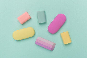 Colorful eraser on color backgroung, top view