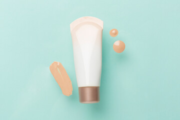 Composition with makeup foundation on color background, top view
