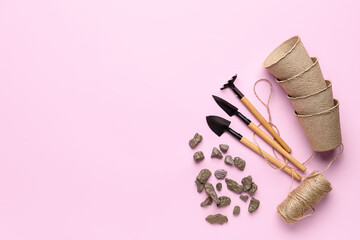 Gardening tools, rocks and peat cups on pink background