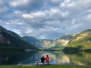 Fototapeta na wymiar couple enjoying the view by the lake, surrounded by mountains