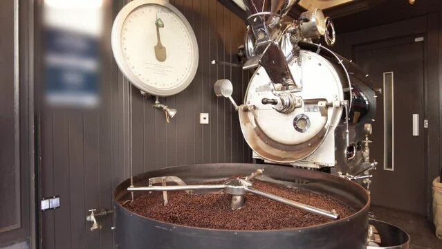 Freshly roasted coffee beans from a large roaster in the cooling cylinder.