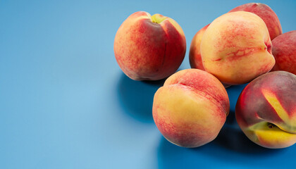 Fresh, ripe peaches on blue background
