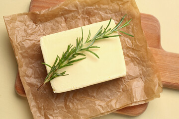 Baking paper with fresh butter and rosemary on yellow background