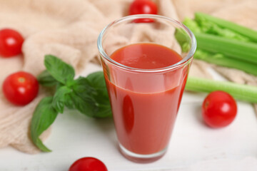 Glass of tasty juice on white wooden background