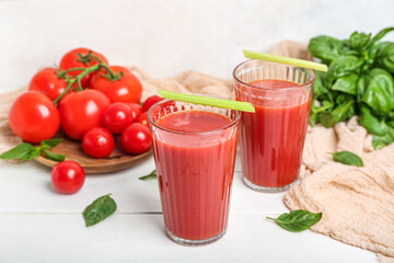 Glasses of tasty tomato juice on table