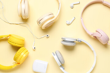 Set of modern headphones and earphones on color background