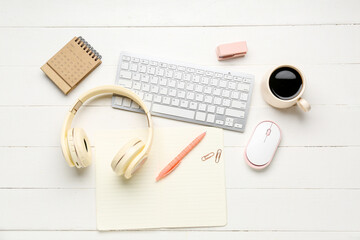 Composition with modern gadgets, stationery and cup of coffee on light wooden background