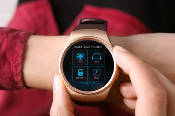 Woman setting smart home control system via smartwatch, closeup. App interface with icons on display
