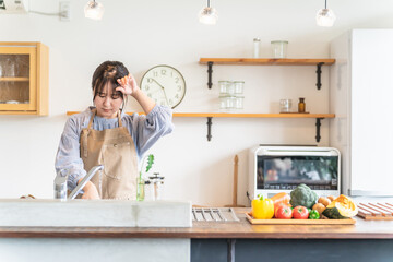 洗い物をする日本人女性（疲労）
