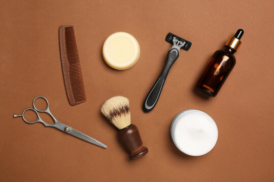 Set of men's shaving tools on brown background, flat lay