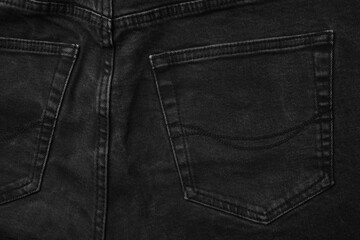 Black jeans with pocket as background, top view