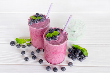 Blueberry Juice smoothies drink in a glass drink purple colorful fruit juice milkshake blend beverage healthy high protein the taste yummy in glass on white wood background.