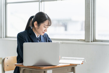 学校の教室・塾でパソコンを使ってオンライン学習する高校生・女子高生
