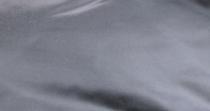 crumpled gray material in close-up, part of the fabric from gray-tinged clothing