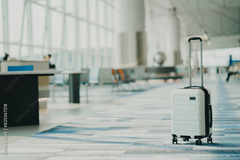 Wall mural the suitcases in an empty airport hall, traveler cases in the departure airport terminal waiting for