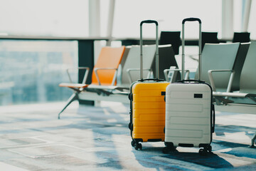 Two suitcases in an empty airport hall, traveler cases in the departure airport terminal waiting for the area, vacation concept, blank space for text message or design - obrazy, fototapety, plakaty
