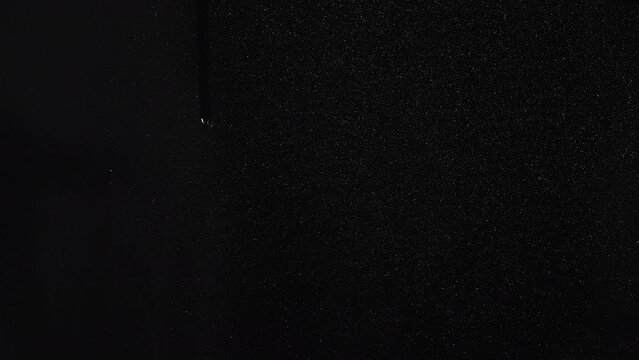 Water drops on a glass surface with a black background 