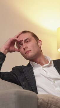 Vertical video. Business contemplation. Startup idea. Strategy plan. Pensive perplexed puzzled man thinking on couch on light free space.